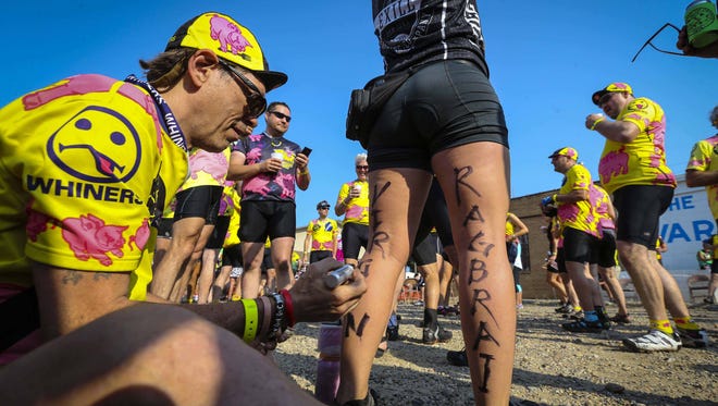 In a RAGBRAI tradition, Team Whiners' Jeff "Crazy" Miller of Denver marks Team Exile's Emily Hoener of Des Moines as a "RAGBRAI virgin" during RAGBRAI 2014.