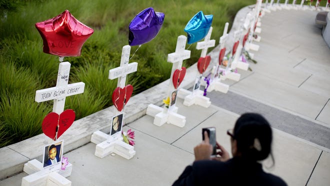 Crosses, one for each victim, line a walkway as a memorial to those killed in the Pulse nightclub mass shooting a few blocks from the club in Orlando, Fla.