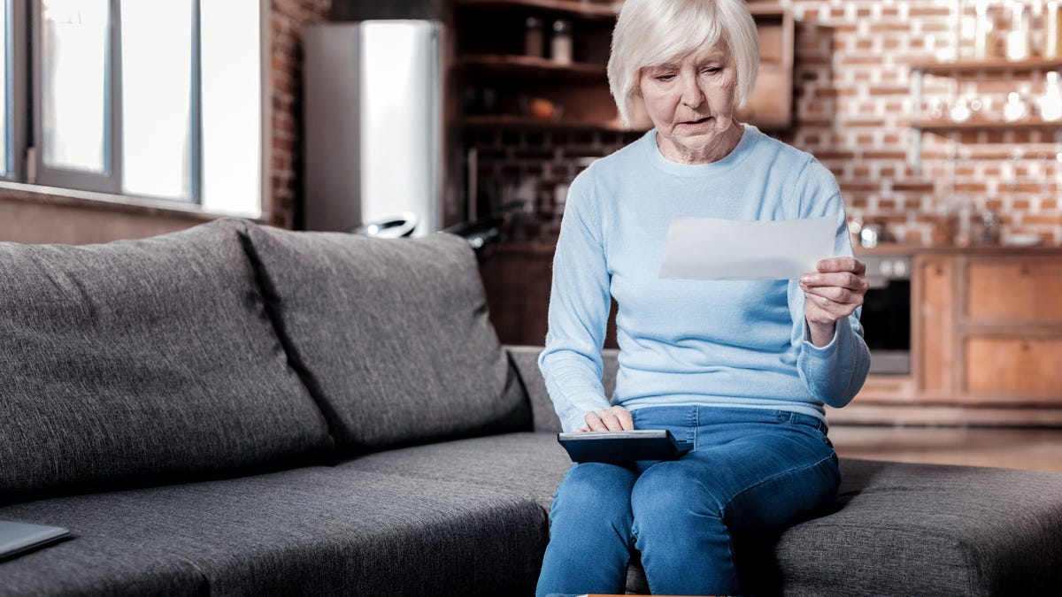 Older lady sitting on couch with Social Security check.