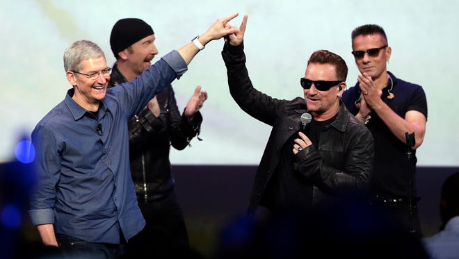 Apple CEO Tim Cook, left, greets Bono after U2 performed at the end of an  Apple event in Cupertino, Calif., on Sept. 9, 2014.