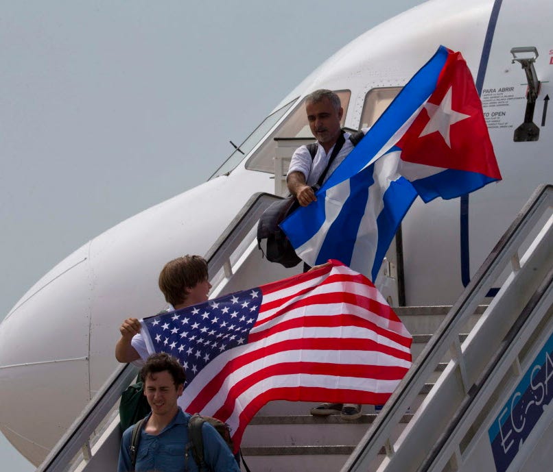 Two passengers deplane from JetBlue Airways flight 387 waving a United States, and Cuban national flag, in Santa Clara.