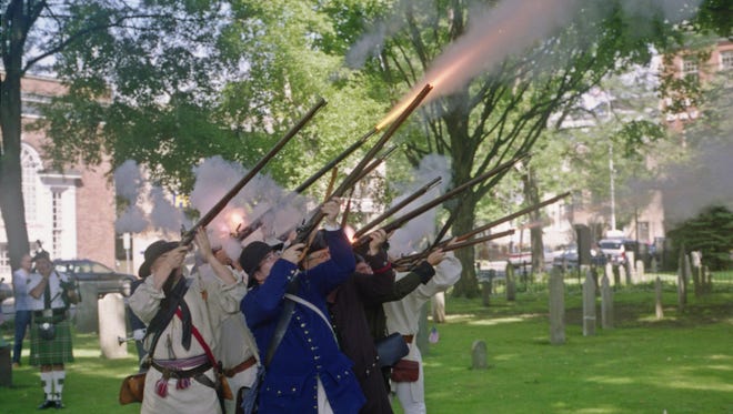Members of the First Ulster Miltia, a Revolutionary War reenactment group, give a musket salute in 2012.