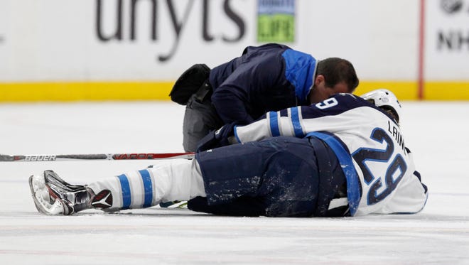 A trainer attends to Winnipeg Jets right wing Patrik Laine (29) after being checked by Buffalo Sabres defenseman Jake McCabe on Jan. 7. Laine suffered a concussion on the play and did not play again until Jan. 24.