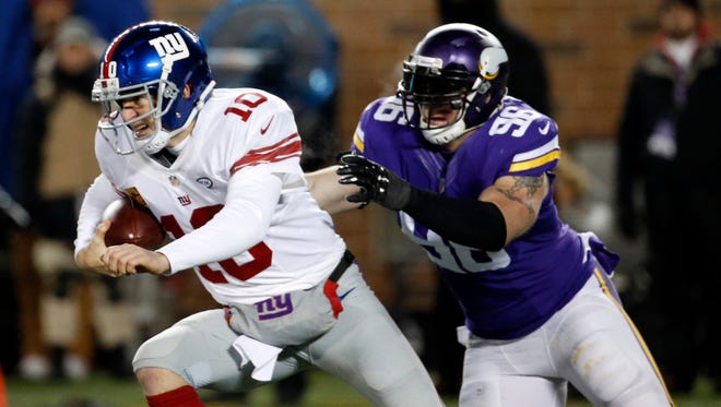 FILE - In this Dec. 22, 2015, file photo, New York Giants quarterback Eli Manning (10) tries to get away from Minnesota Vikings defensive end Brian Robison during the first half of an NFL football game in Minneapolis. In seven career starts against the Vikigns, Manning has a 2-5 record with a rough 54.8 passer rating. He’s thrown for only five touchdowns, and five of the 14 interceptions by the Vikings have been taken to the end zone.