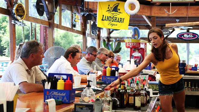 Becky Patterson of Crescent Springs tends the bar at the Ludlow Bromley Yacht Club. The bar opens for its 20th season Thursday, April 28.