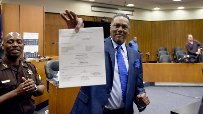 Richard Phillips shows his order of dismissal of homicide in Judge Cox's courtroom in Detroit on Wednesday. March 28, 2018. A bill that would add money to the state fund to compensate those wrongfully convicted has been vetoed by the governor.