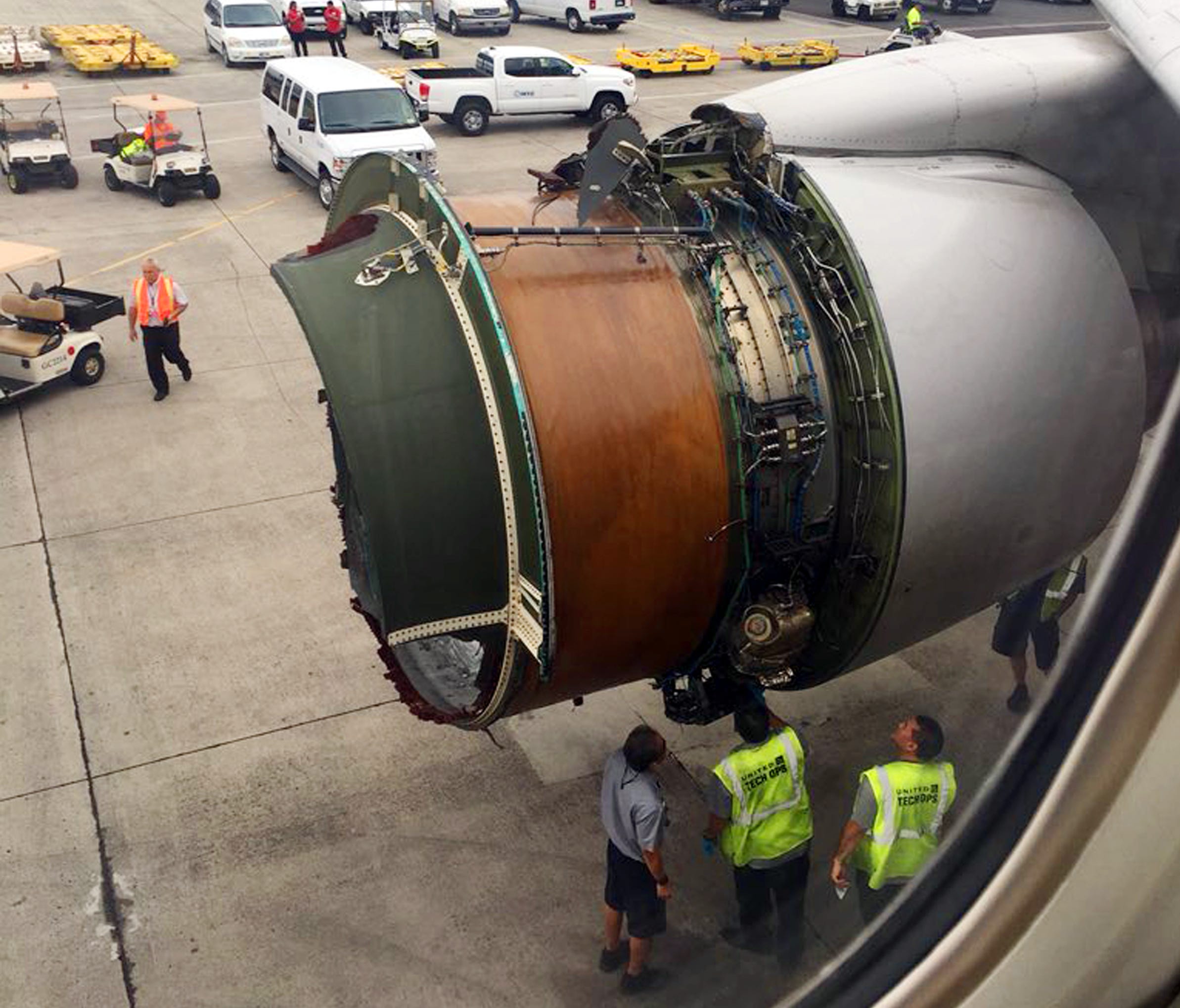 This photo provided by passenger Haley Ebert shows damage to an engine of a Boeing 777 after parts came off the jetliner during its flight from San Francisco to Honolulu on Tuesday, Feb. 13, 2018. The plane landed safely as emergency responders waite