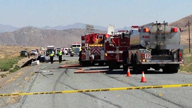 Emergency personnel work at the site of a collision between a pickup truck and a small airplane which was making an emergency landing on Nevada Route 445, about 20 miles north of Reno, Nev. on Saturday, July 26, 2014.