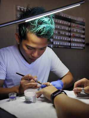 Tony Ly, owner of Tony's Nails, applies a refill on Jordan Myers' acrylic nails. Ly has been doing manicures and nail design for 14 years.
