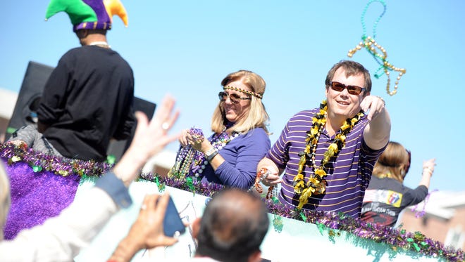 A parade participant throws beads from a float during the annual Caerus Mardi Gras Parade in Hattiesburg. City officials say they want to continue to allow throws during parades in the city.