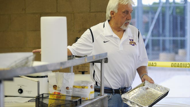 Unioto High School booster club president Jim Green prepares to fry fish at the club's concession stand Friday at the Unioto High School football game.