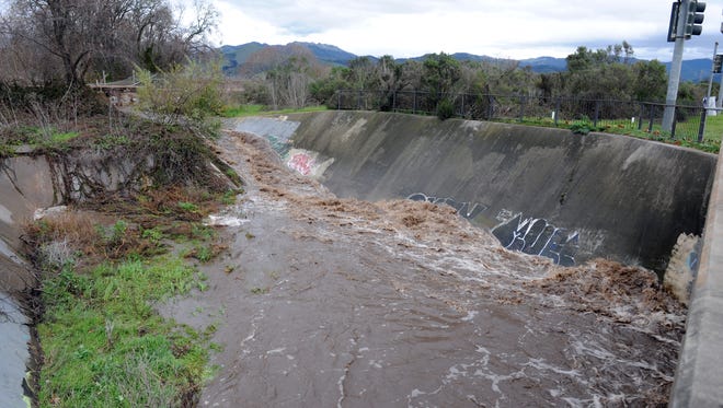 Overnight rains on Saturday send a muddy torrent down this Natividad Creek tributary in north Salinas. 
