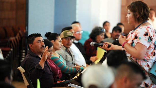 A resident asks a question of Paz Padilla of Catholic Charities at an immigration forum held on Sunday, April 2nd at St. John the Baptist Church in King City, CA. 