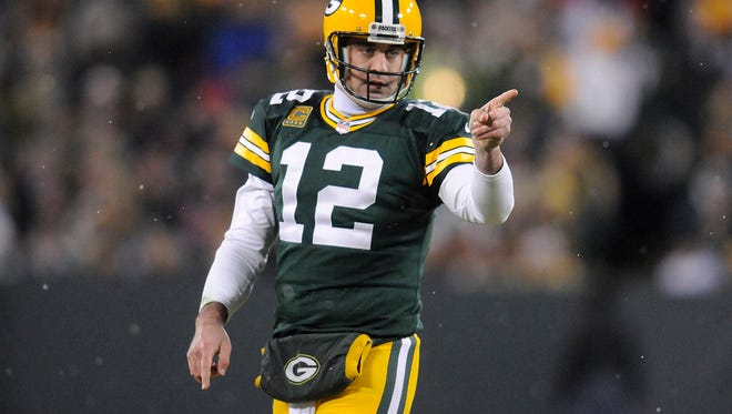Green Bay Packers quarterback Aaron Rodgers (12) signals for a first down against the Detroit Lions during Sunday's game at Lambeau Field.