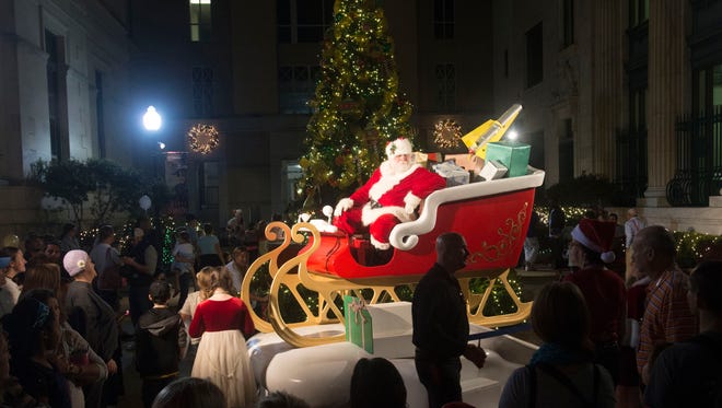 A large crowd gathers around Santa Clause outside the Artel Gallery to get a good look at the top Elf at the end of Friday night's Elf Parade. The annual event marks the kickoff to Winterfest and the lightning of the Christmas lights along Palafox Street.