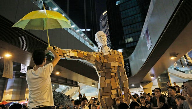 A statue holding a yellow umbrella is set up by students outside government headquarters in Hong Kong.