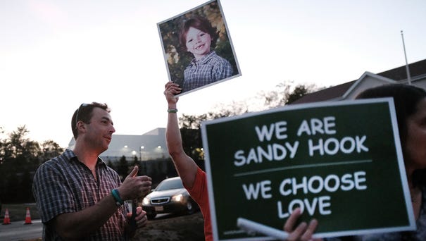 Mark Barden holds up a picture of his son Daniel...