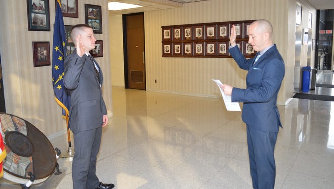 Mayor Dave Snow, right, swears in Blake Hogan on Hogan's first day as a Richmond Police Department officer Monday.