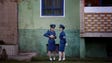 North Korean traffic police women chat next to a residential