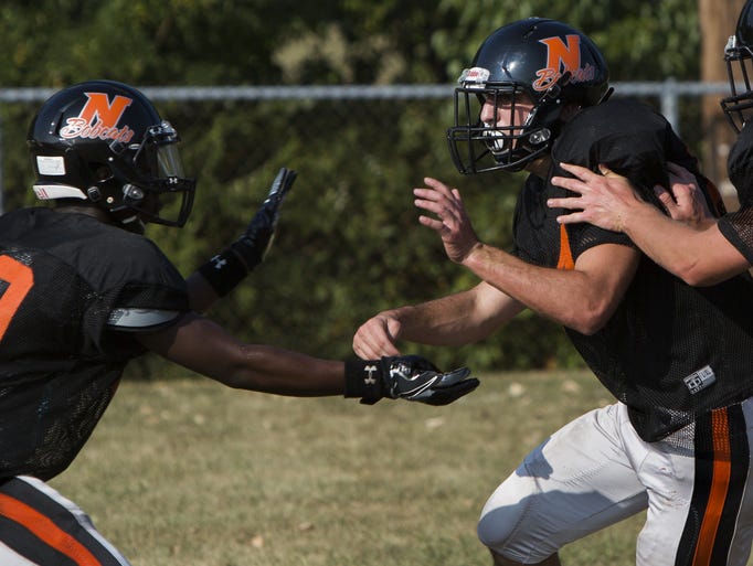 Northeastern linebacker Mason Kling, center, rushes