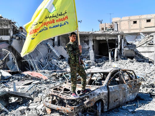 A member of the Syrian Democratic Forces holds its