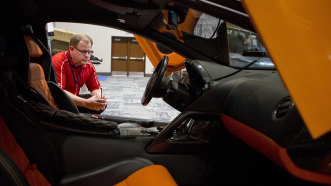 Jim Langolf, of Port Huron, peers into a Lamborghini during the 100 Men charity event Thursday, September 10, 2015 at the Blue Water Convention Center in Port Huron.