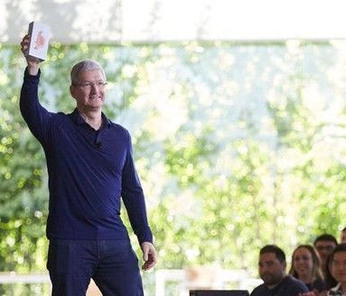 Tim Cook holding the billionth iPhone. Apple's CEO announced a planned $1 billion investment in a U.S. manufacturing fund.