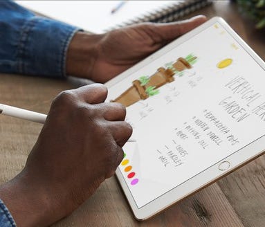 A person using an Apple Pencil with an iPad Pro.