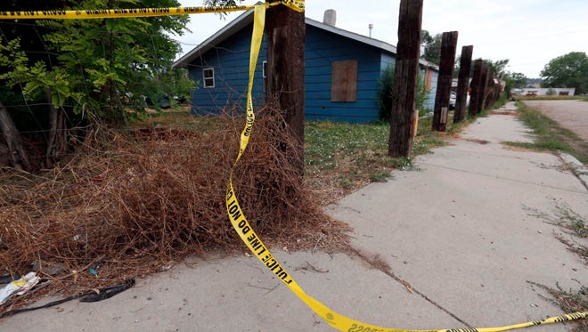 In this Saturday, Aug. 5, 2017, photo, crime scene tape surrounds a property at Helen Street and Second Avenue in Lodge Grass, Mont. No criminal charges will be brought in the case, prosecutors announced.