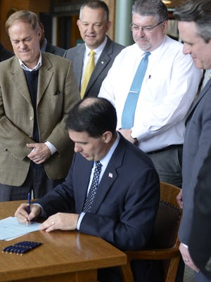 Gov. Scott Walker signs a law Tuesday making more liquor licenses available for projects such as the Green Bay Packers' Titletown District. March 29, 2016.