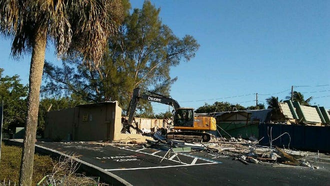 A crew works to demolish the old retail strip at the corner of Fifth Avenue North and Goodlette-Frank Road. The site is planned for a 7-Eleven convenience store and gas station.