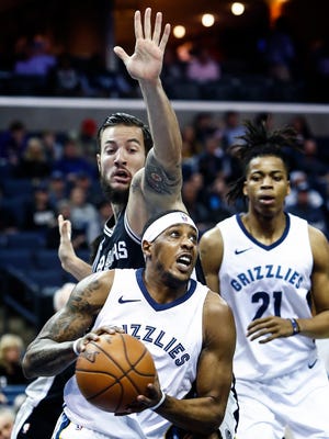 Memphis Grizzlies guard Mario Chalmers (bottom) drives to the basket against San Antonio Spurs defender Joffrey Lauvergne (top) as Deyonta Davis (right) looks on during first quarter action at the FedExForum in Memphis, Tenn., Wednesday, January 24, 2018.