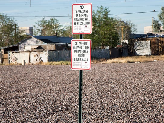 A "no trespassing" sign marks a city-owned gravel lot
