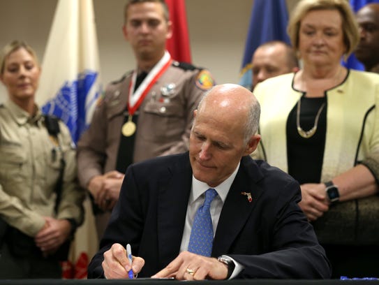 Gov. Rick Scott signs a bill into law that gave state workers a pay raise in 2017.
