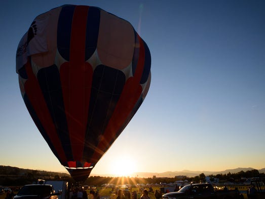The first balloon begins inflation at the Reno Balloon