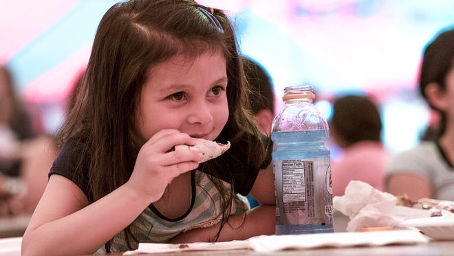 The Cristo Rey Fiesta is back this weekend. Pictured: Gabriella Flegler from Holt enjoying a barbacoa taco in 2015.