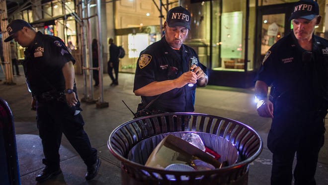 Police officers look for suspicious packages along Fifth Avenue near the scene of an explosion on West 23rd Street and 6th Avenue in Manhattan's Chelsea neighborhood, in New York, early Sunday, Sept. 18, 2016. An explosion rocked the block of West 23rd Street between Sixth and Seventh Avenues at 8:30 p.m. Saturday. Officials said more than two dozen people were injured. Most of the injuries were minor. (AP Photo/Andres Kudacki)