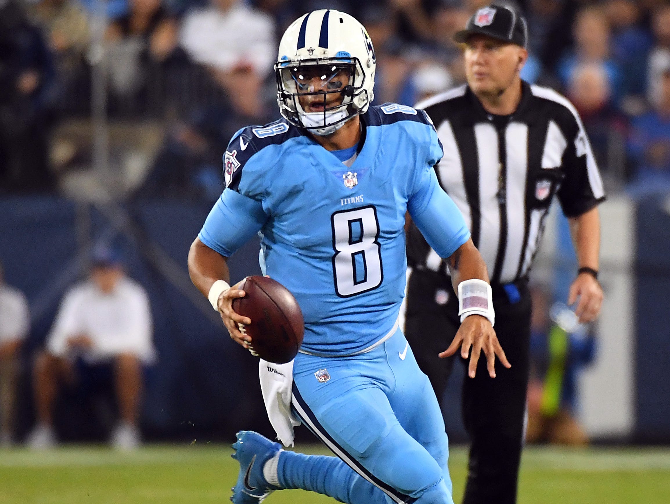 Tennessee Titans quarterback Marcus Mariota (8) runs for a first down in the first half against the Jacksonville Jaguars at Nissan Stadium.