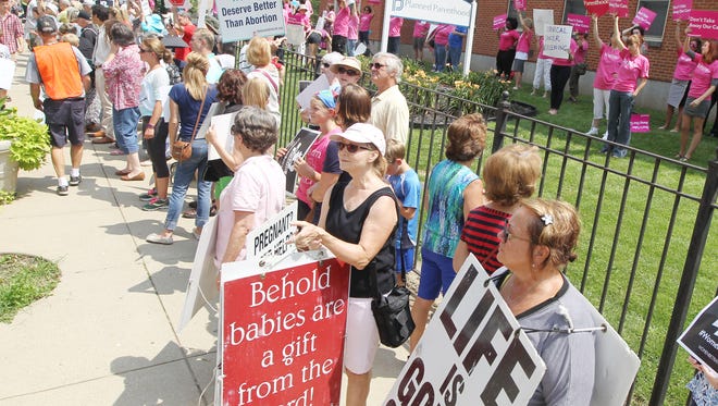 Hundreds of people demonstrating against abortion outside Planned Parenthood in Mount Auburn were met with counter-demon-
strators inside the fence.
A new proposal would require a 15-foot buffer for anti-abortion protesters.