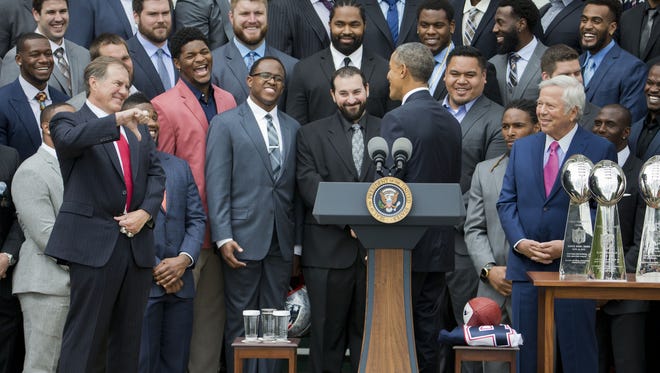 New England Patriots coach Bill Belichick, left, gives 'thumbs-down' to a joke President Barack Obama made during a ceremony welcoming the Super Bowl Champion New England Patriots, Thursday, April 23, 2015, on the South Lawn of the White House in Washington, to honor the team and their Super Bowl XLIX victory. On the right is Robert Kraft Chairman and CEO of the New England Partriots.
