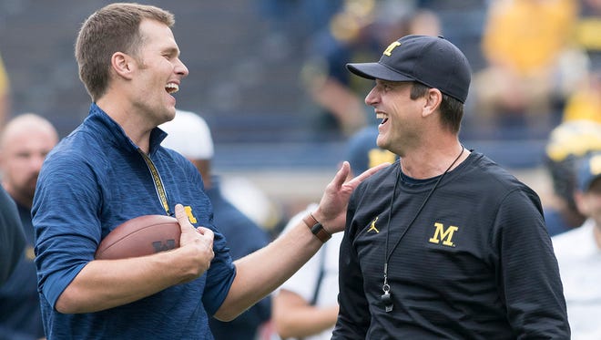 Wolverines honorary captain Tom Brady, left, and Michigan head coach Jim Harbaugh meet on the field on Saturday afternoon during warm-ups before the Michigan-Colorado football game at Michigan Stadium in Ann Arbor.