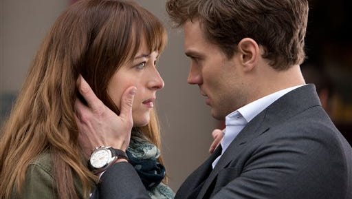In this image released by Universal Pictures and Focus Features, Dakota Johnson, left, and Jamie Dornan appear in a scene from the film, "Fifty Shades of Grey."  (AP Photo/Universal Pictures and Focus Features)