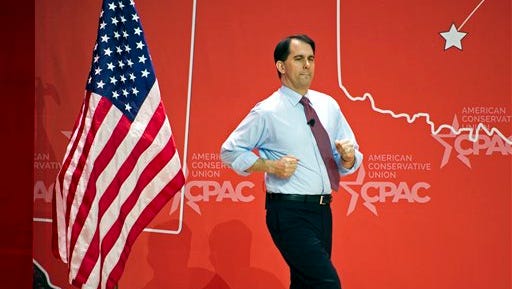 Wisconsin Gov. Scott Walker runs onstage to address the  Conservative Political Action Conference (CPAC) in National Harbor, Md., Thursday, Feb. 26, 2015. (AP Photo/Cliff Owen)
