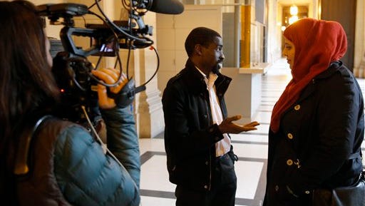 FILE - In this Feb.25, 2015 file photo, plaintiff Bocar, center, is interviewed by the media at the Paris appeals court in Paris, France. A French appeals court has ruled Wednesday June 24, 2015 that police carried out unjustified identity checks on five minority men, ordering the government to pay them damages in an unprecedented ruling that activists hope will help reduce widespread discrimination. (AP Photo/Francois Mori, File)