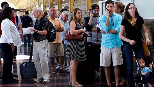 People stand in line at Washington's Reagan National Airport after technical issues at a Federal Aviation Administration center in Virginia caused delays on Saturday, Aug. 15, 2015. (AP Photo/Jacquelyn Martin)