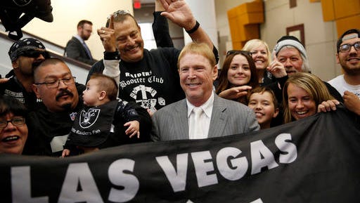 FILE - In this April 28, 2016, file photo, Oakland Raiders owner Mark Davis, center, meets with Raiders fans after speaking at a meeting of the Southern Nevada Tourism Infrastructure Committee in Las Vegas. Nevada lawmakers convene Monday, Oct. 10, 2016, to consider raising taxes in the Las Vegas area to help fund a $1.9 billion football stadium, a $1.4 billion convention center expansion and more police officers to protect the additional tourists. (AP Photo/John Locher, File)