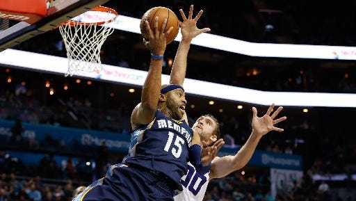 Memphis Grizzlies guard Vince Carter (15) passes the ball behind his head while Charlotte Hornets forward Spencer Hawes (00) defends during the first half at Spectrum Center.