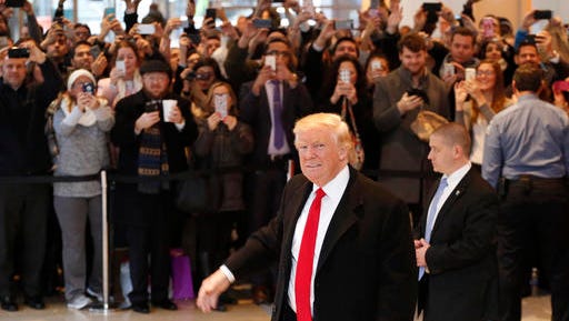 President-elect Donald Trump walks past a crowd as he leaves the New York Times building following a meeting, Tuesday, Nov. 22, 2016, in New York.