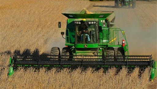 A crop farmer uses a John Deere combine to harvest his soybean field in Loami, IL..