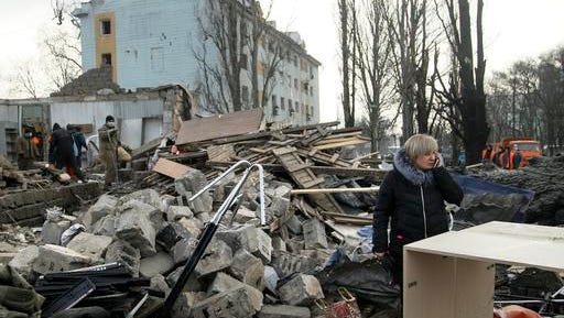 A woman speaks on her cell phone amonst the ruins of a building after shelling in Donetsk, eastern Ukraine, Friday, Feb. 3, 2017.  Heavy shelling hit both government- and rebel-controlled areas of eastern Ukraine as fighting continues Friday, and international monitors issued a sharp call for the sides to still their guns.